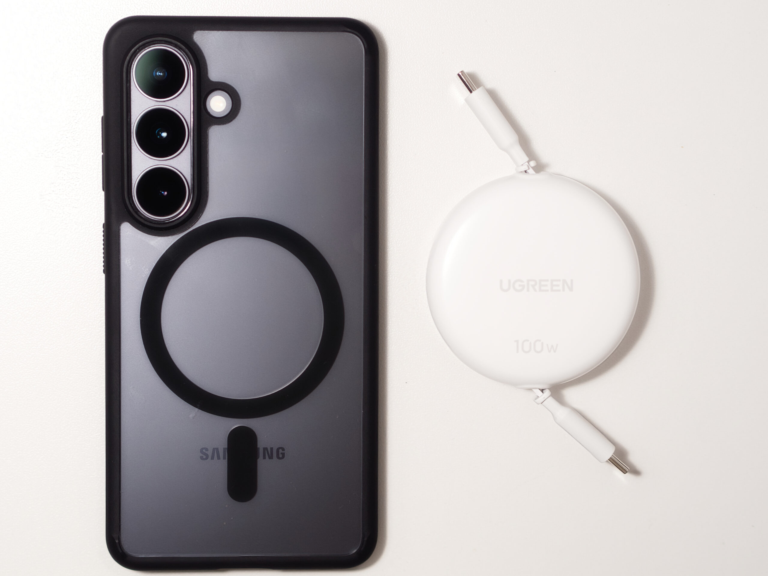 UGREENの巻き取りUSB-CケーブルとGalaxy S26スマートフォンを並べたサイズ比較